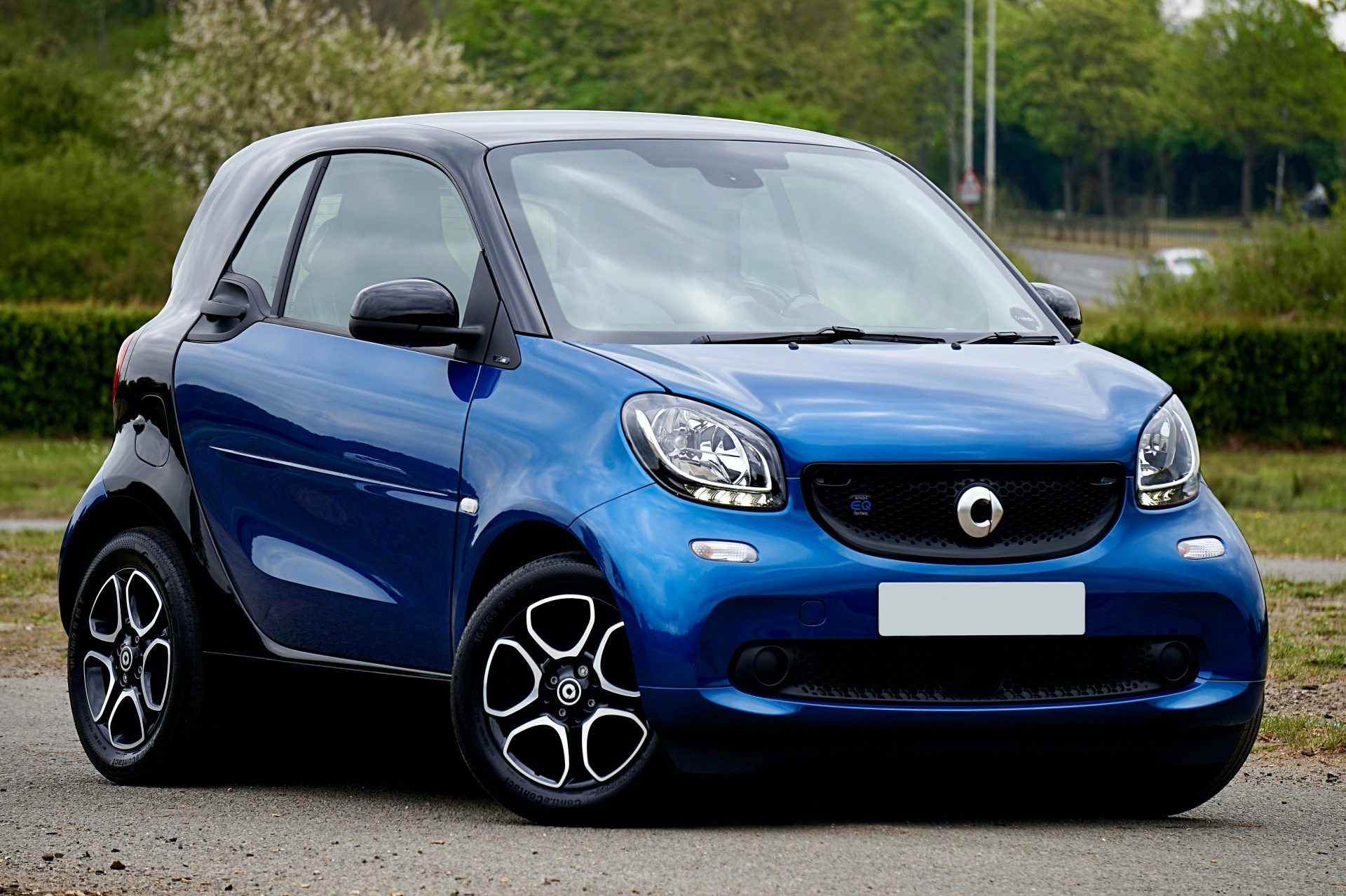 Une voiture électrique bleue et brillante, garée en extérieur par une belle journée au Royaume-Uni.