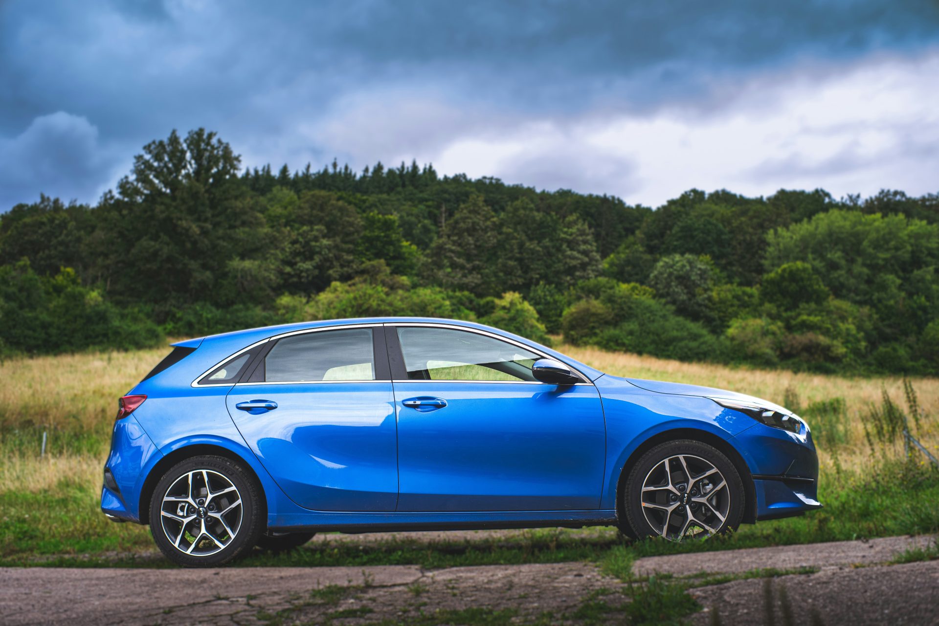 Une voiture bleue garée sur le bord d'une route.